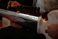 Tarun Jasani tunes his Sarod. As you can see, the fingerboard has no frets and the strings are metal wire, not synthetic, but the player only uses his fingers, not a slide - I imagine it can be painful when you're just learning!