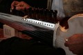 Tarun Jasani tunes his Sarod. As you can see, the fingerboard has no frets and the strings are metal wire, not synthetic, but the player only uses his fingers, not a slide - I imagine it can be painful when you're just learning!