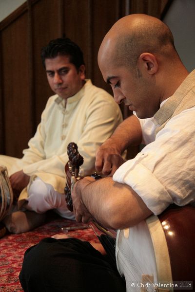 Tarun Jasani tunes his Sarod. There are two sets of tuning pegs, the further ones for the longer strings, which are spaced further apart, and the closer ones for a second set of strings that are close together.