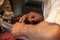 Tarun Jasani tunes his Sarod. There are two sets of tuning pegs, the further ones for the longer strings, which are spaced further apart, and the closer ones for a second set of strings that are close together.