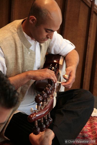 Tarun Jasani tunes his Sarod. There are two sets of tuning pegs, the further ones for the longer strings, which are spaced further apart, and the closer ones for a second set of strings that are close together.